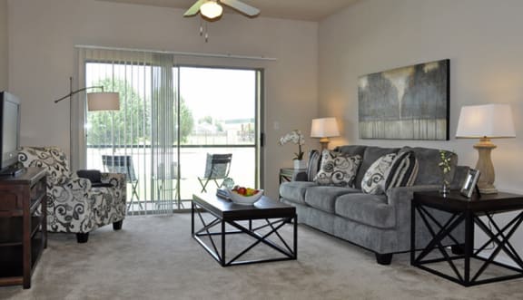 a living room with a sliding glass door leading to a balcony