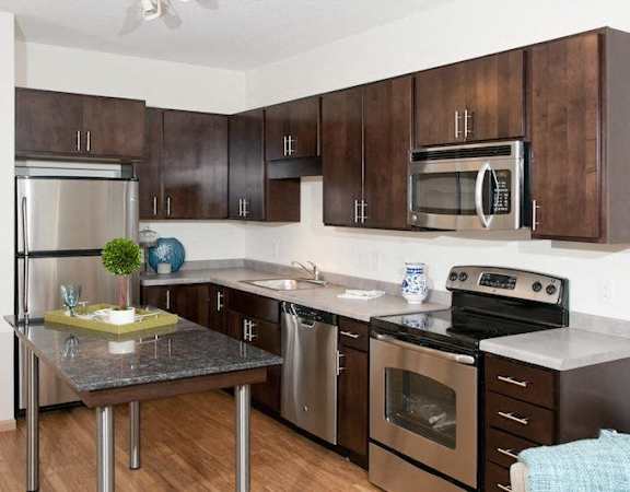 A kitchen with brown cabinets and stainless steel appliances.