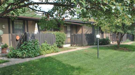 a small house with a yard and a fence