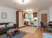 Thumbnail 5 of 6 - a living room and kitchen with a couch and a table