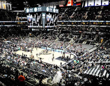A basketball game is being played in a large arena.