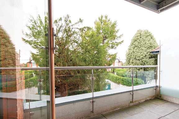 a balcony with a view of a courtyard and trees