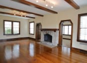 Thumbnail 5 of 8 - an empty living room with wood floors and a stone fireplace