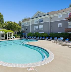 A large outdoor swimming pool with a pavilion and sun loungers.