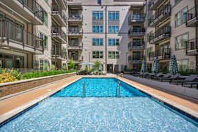 A swimming pool in front of apartment buildings.