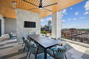 A patio with a table and chairs and a TV on the wall.