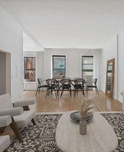 a dining area with a wooden table and chairs and a kitchen in the background
