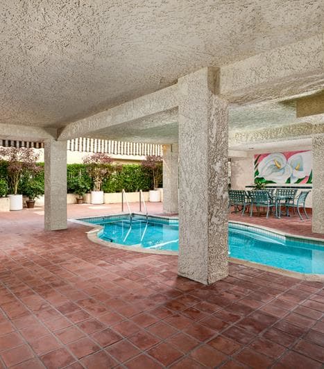 a swimming pool in the middle of a room with columns