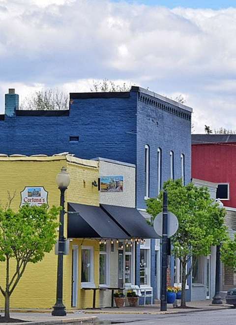 A street view of a town with a car parked on the side of the road.