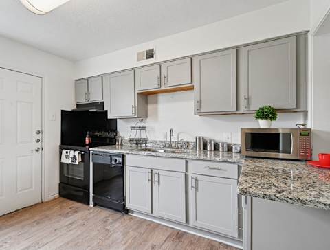 A kitchen with a black oven and microwave.