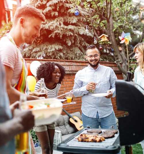 A group of people are gathered around a barbecue grill at Chelsea Place Apartments, Lithonia, GA