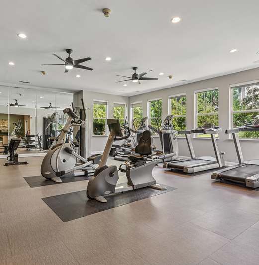 A spacious gym with treadmills, elliptical machines, and other exercise equipment.