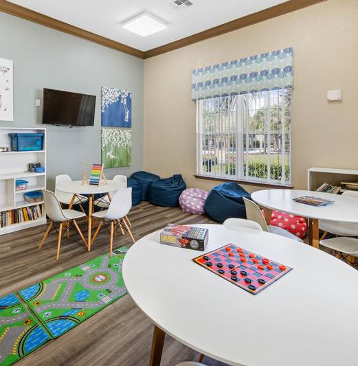 A room with a white table, chairs, and a world map on the wall.