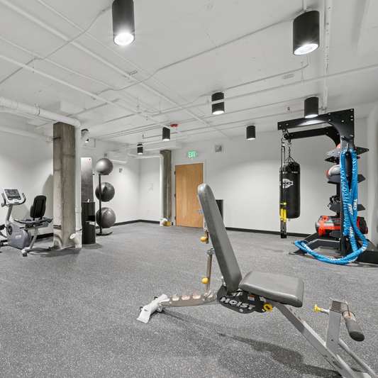 A gym with treadmills, exercise equipment and a weight rack.