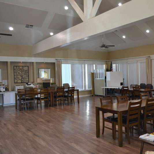 A spacious living room with a large wooden table and chairs.