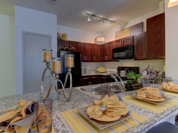 A kitchen with a table set for two.