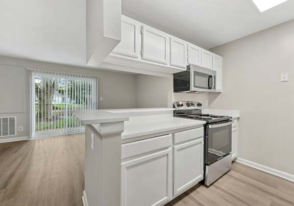A kitchen with white cabinets and stainless steel appliances.