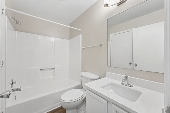 A white bathroom with a toilet, sink, and bathtub.