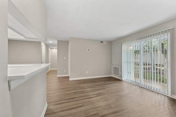 A spacious room with wooden floors and white walls.