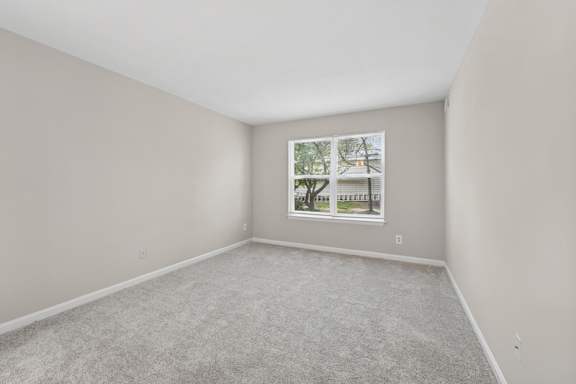 A room with a carpeted floor and a picture frame on the wall.