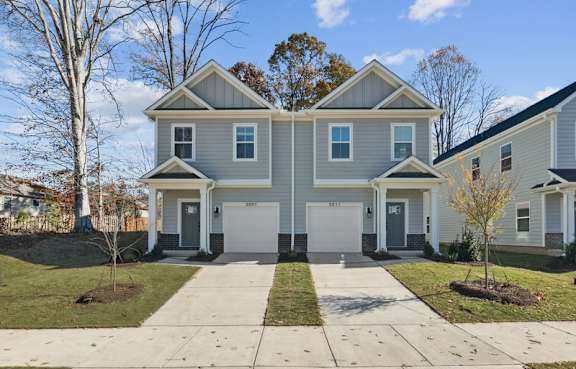 A two-story house with a grey exterior and white trim.