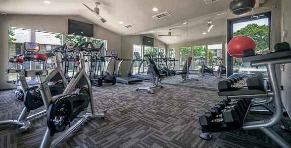a gym with a lot of exercise equipment and windows at Rock 35, Texas