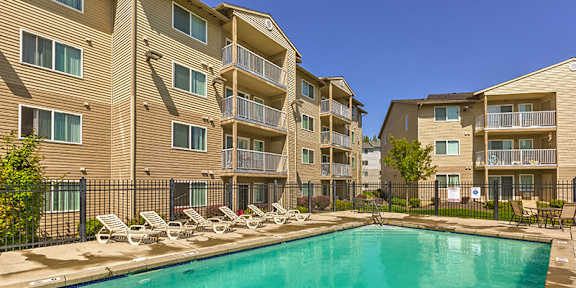 a man and woman with a little girl holding balloons and a bag at FOREST CREEK APARTMENTS, Washington, 99208