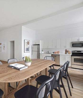 A modern dining room with a wooden table and chairs.