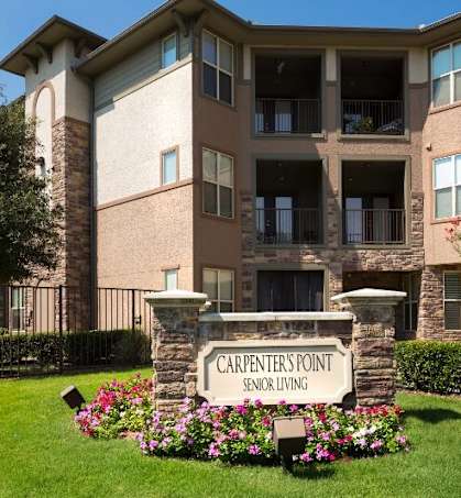 an apartment building with a sign in front of it