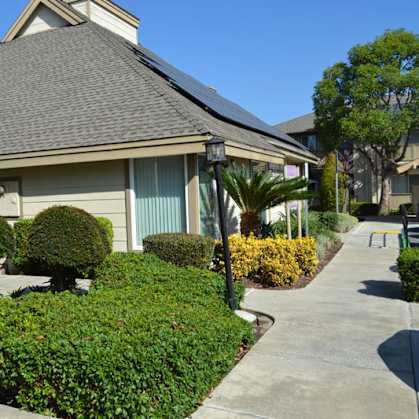 A house with a grey roof and a green lawn.