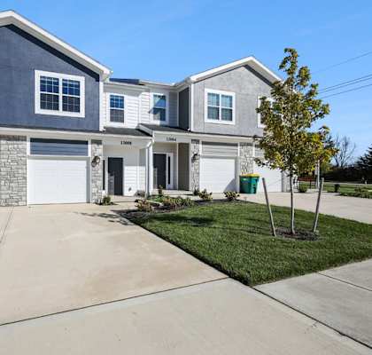 A two-story house with a garage and a driveway.