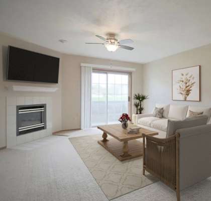 A living room with a fireplace and a flat screen TV mounted on the wall.