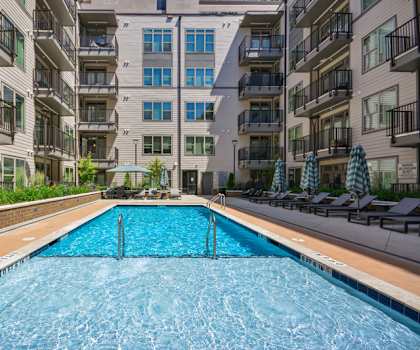 A swimming pool in front of apartment buildings.