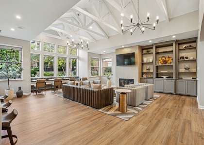 A spacious living room with a fireplace and a large chandelier.