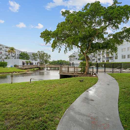 A pathway leads to a Welcome Center in a tropical setting.