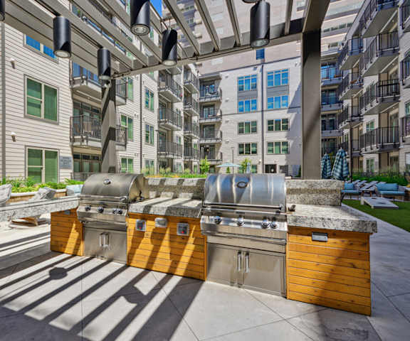 A modern outdoor kitchen with a grill and sink.