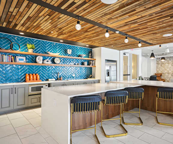 A kitchen with a bar area and a wooden ceiling.