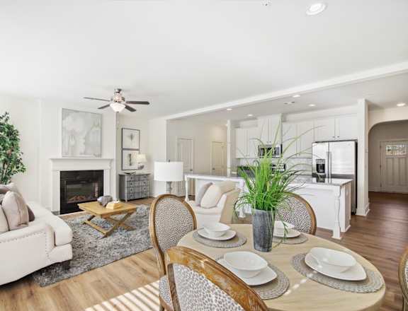 a living room and dining room with a table and chairs