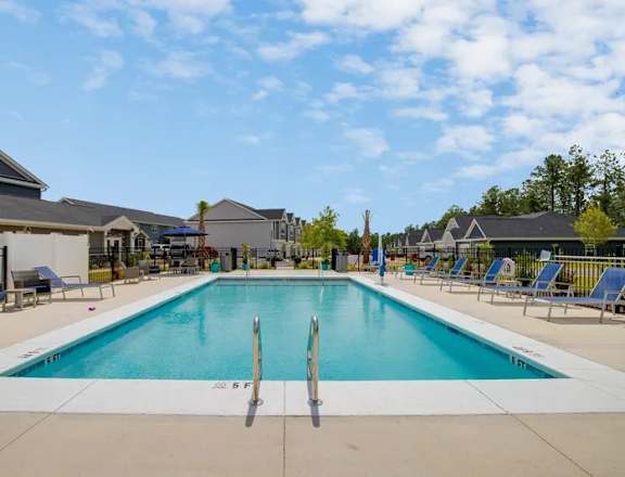 A large swimming pool with a diving board in the middle of it.