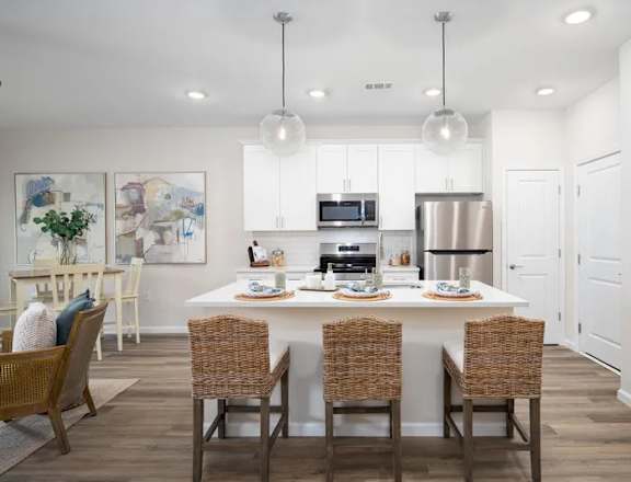 A modern kitchen with a dining table set for four.