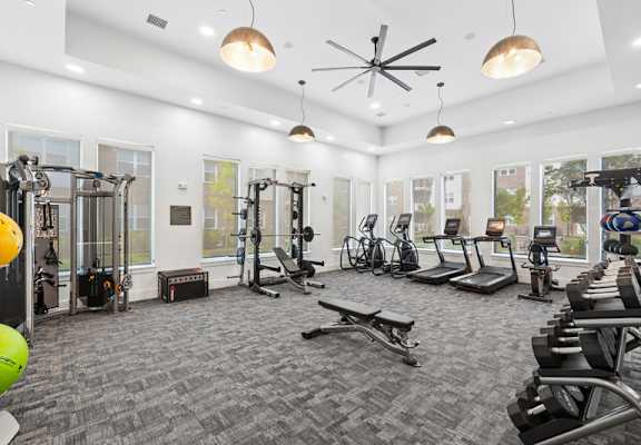 A spacious gym with a variety of equipment including treadmills, weights, and exercise machines.