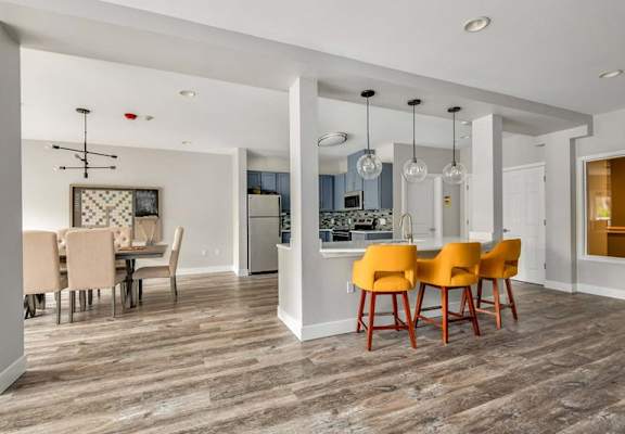 A modern dining room with a wooden floor and a dining table with chairs.