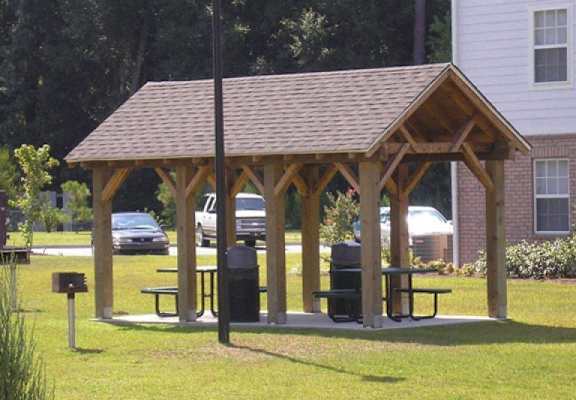 a man sitting on a picnic table in a pavilion