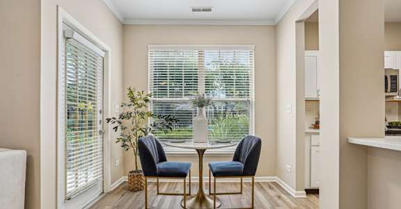 A room with a table and two chairs in the middle.