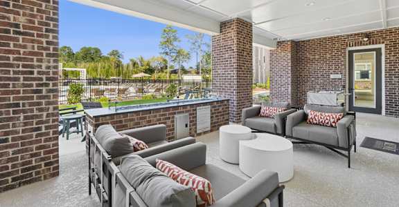 A patio with grey couches and a white table.