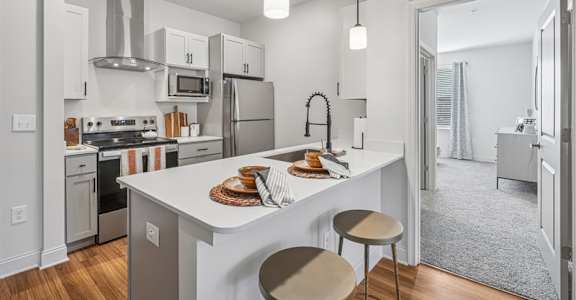 A modern kitchen with a white island and stainless steel appliances.