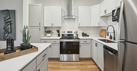 A modern kitchen with stainless steel appliances and white cabinets.