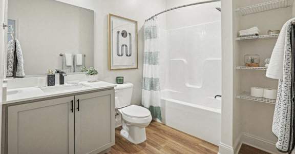 A bathroom with a toilet, sink, and shower.