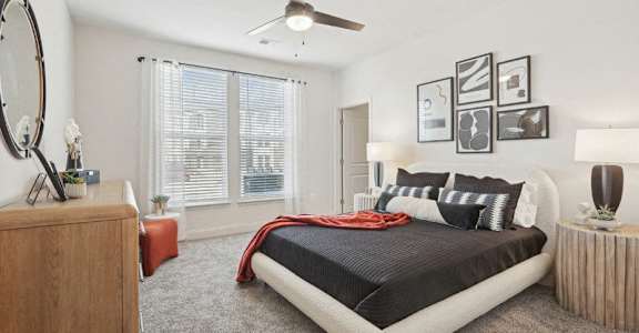 A bedroom with a large bed and a wooden dresser.