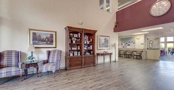 A living room with a wooden floor and a large clock hanging from the ceiling at VINTAGE AT CHEHALIS Apartments, Chehalis , WA 98532